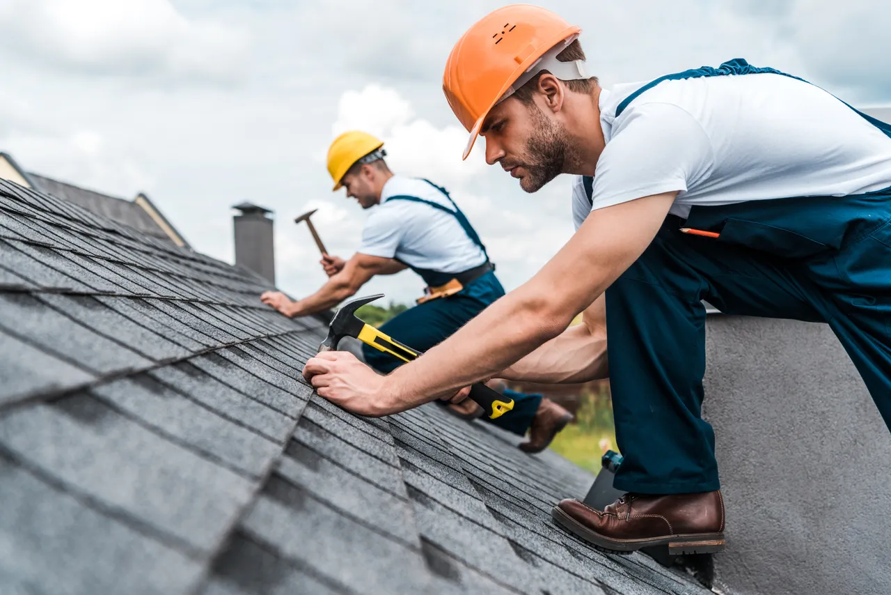 Roofers working on a roof with tools and materials, demonstrating craftsmanship and professionalism